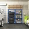 Stålreol med dæk, kufferter og værktøj i garage.