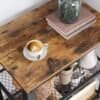Træbord med kop kaffe, bøger og dekorative elementer.