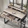Moderne toiletbord med 3 skuffer, spejl og dekorative accessories.