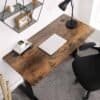 Stilfuldt hjemmekontor med træbord, lampe og laptop.