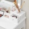 Organiseret makeup- og skønhedsprodukter i hvid opbevaringsboks.