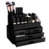 Sort makeup organizer med makeupbørster, neglelak og kosmetik i skuffer.
