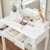 Hvid Vasagle make-up bord med spejl, makeup, og dekorative elementer.