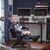 Kvindelig gamer sidder afslappet i ergonomisk gaming-stol.