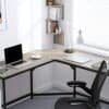 Hjørnebord til hjemmekontor med laptop, lampe og bøger.