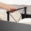 Foldbar sengestel med metalramme til opbevaringskasse.