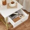 Moderne hvidt og guld bedside bord med skuffe og hylde til soveværelse.