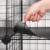 Person monterer sort wire grid opbevaringshylde til opbevaring.