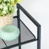 Sort metal hylde med mesh design til badeværelse eller køkken.