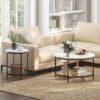 Elegant stue med beige sofa, sort sofabord og hvide hylder.