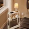 Kompakt sidebord med power strip og lampe i soveværelse.