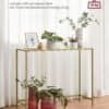Elegant konsolbord med lys guld metalstel og hærdet glasplade.