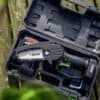 Elektrisk mini kædesav i kuffert med batteri og oplader.