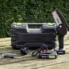 Elektrisk mini kædesav med batteri og tilbehør til havearbejde.