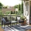 Balkon med to sorte loungestole, sidebord og grønne planter.
