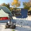 Foldbar campingstol i blå med armlæn og kopholder til udendørs brug.