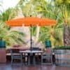 Orange balkonparasol med vippefunktion og UPF 50+ beskyttelse.