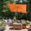Orange balkonparasol med vippefunktion og UPF 50+ beskyttelse.