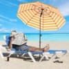 Strandparasol med orange og hvide striber på strand.