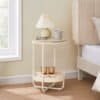 Elegant natbord med lampe, kop og brune lysestager ved sengen.