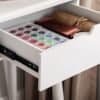 Hvid makeup- og kreative organiser med farvede pigmenter og materialer.