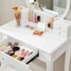 Hvid makeup bord med spejl og makeup produkter til skønhedspleje.