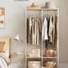 Vægmonteret garderobe med tøj og opbevaringskasser.