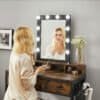 Vægspiegel med LED-lys og træskab til makeup og skønhedspleje.