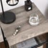 Moderne sidebord med glas, ur og bordlampe i stue eller soveværelse.