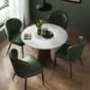 Elegant spisebord med fire grønne læderstole i et moderne hjem.