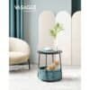 Moderne rund sidebord med stofkurv og plante i stue.