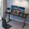 Moderne hjemmekontor med elektrisk hæve-sænkebord og dual monitor setup.