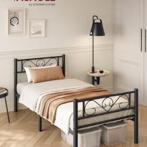 En sort metal seng med hvidt sengetøj og beige pude i et moderne soveværelse.